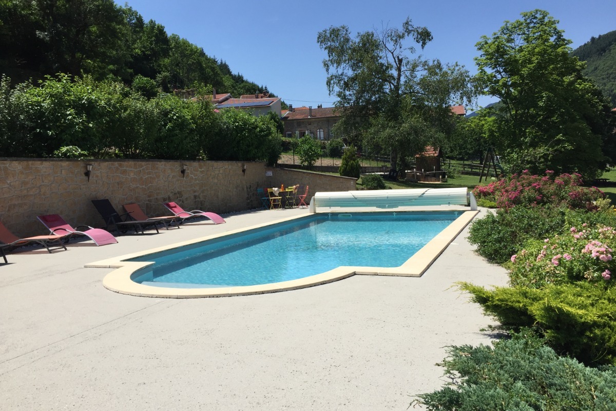 piscine avec transats, petit salon et douche solaire