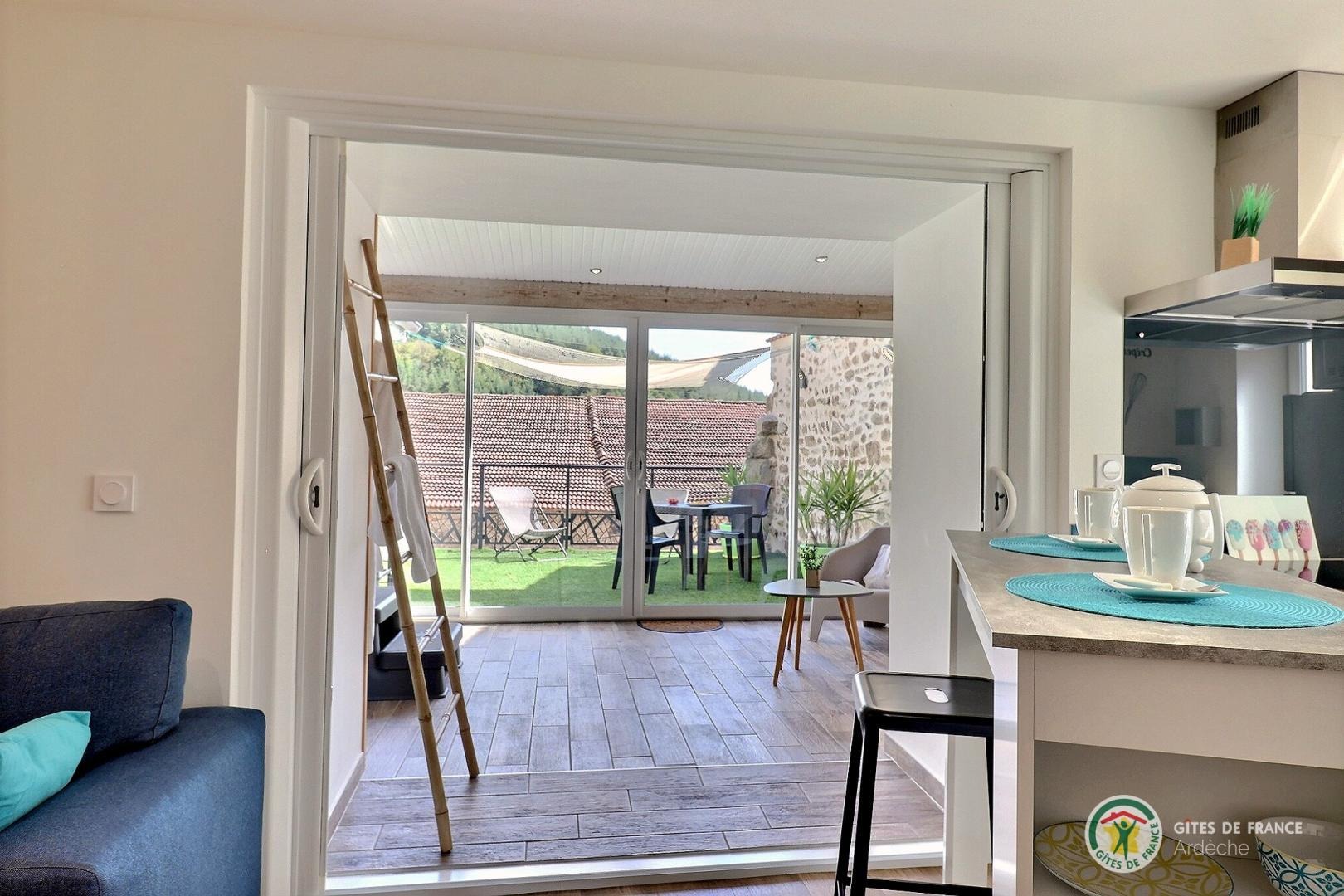 Vue sur la véranda avec jacuzzi privatif, espace salon et accès terrasse direct. 