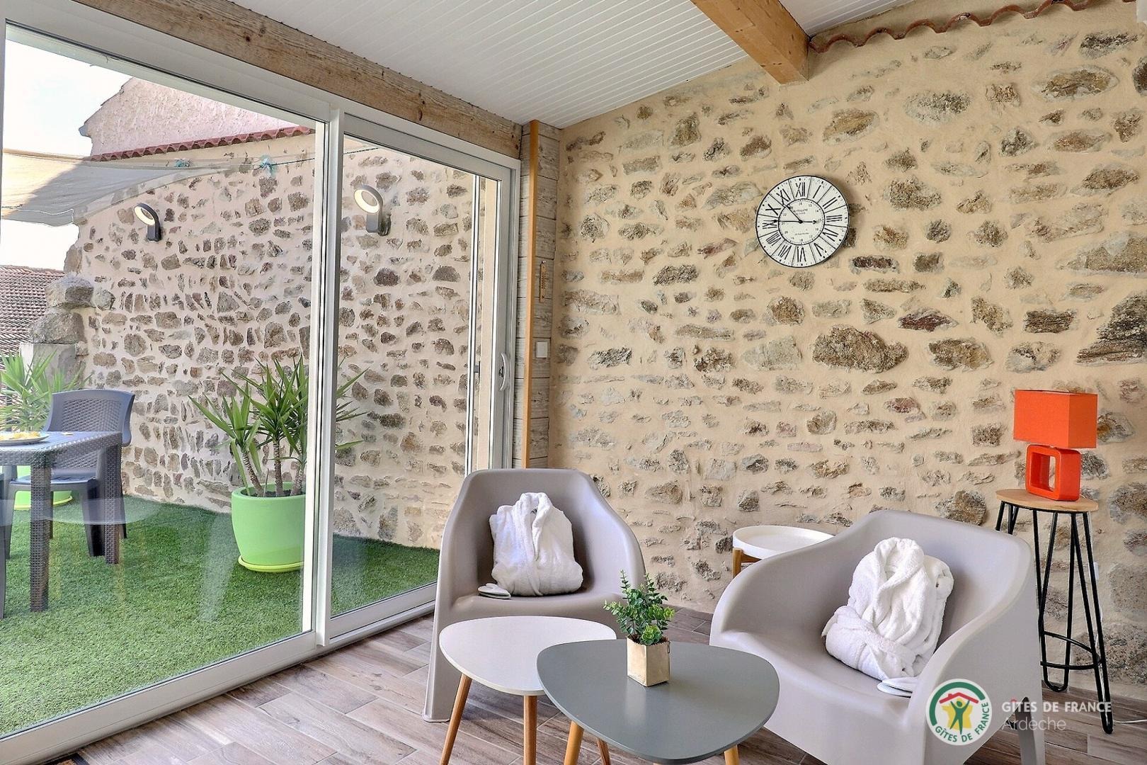 Espace salon véranda et vue sur la terrasse.