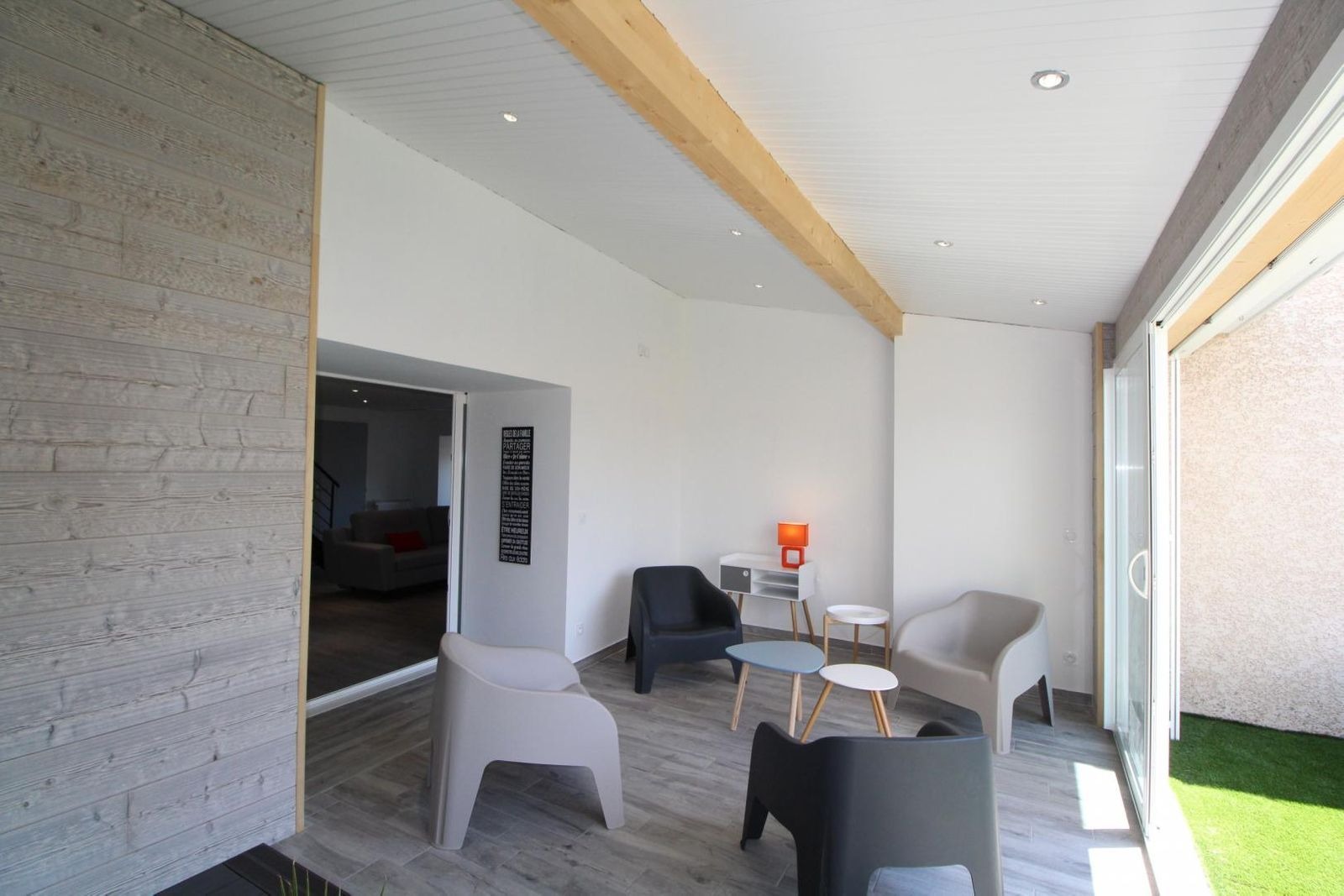 Espace salon dans la véranda chauffée l'hiver et climatisée l'été donnant sur la terrasse