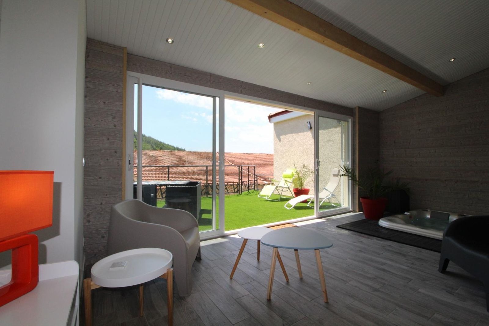 Espace salon dans la véranda avec jacuzzi encastré et privatif à l'appartement, et vue sur la terrasse
