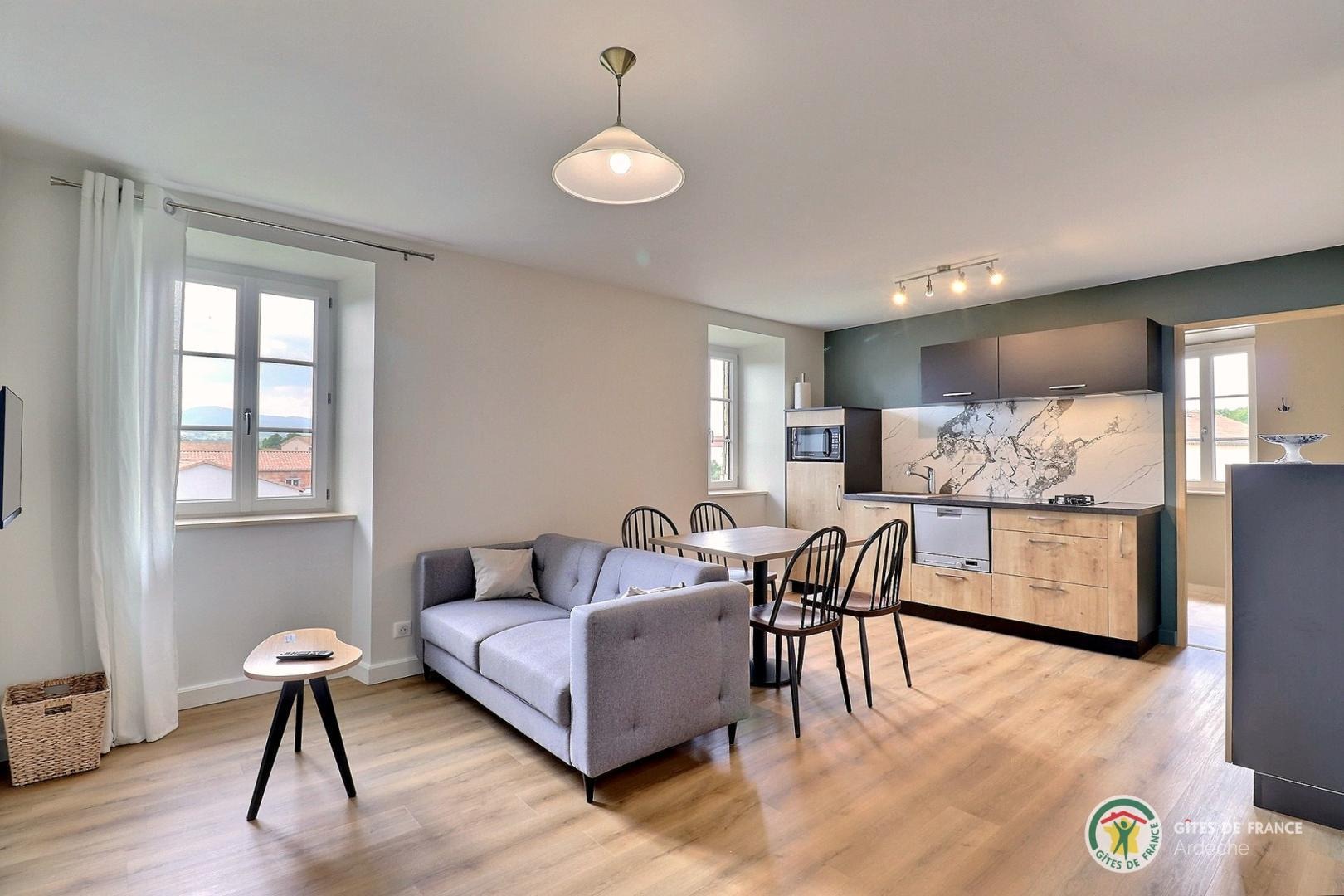 Pièce de vie avec coin cuisine équipée et salon