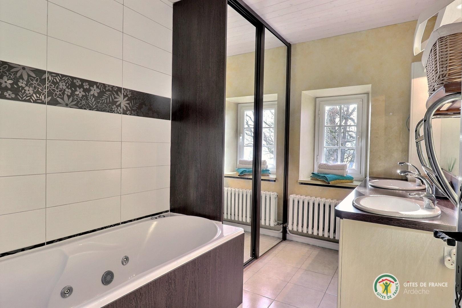 Salle de bain avec baignoire et meuble double vasque