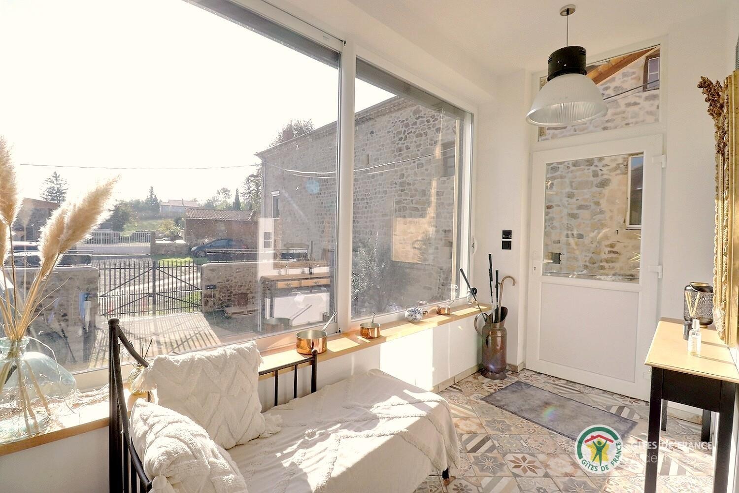 Entrée ouverte sur la pièce de vie, avec vue sur la cour